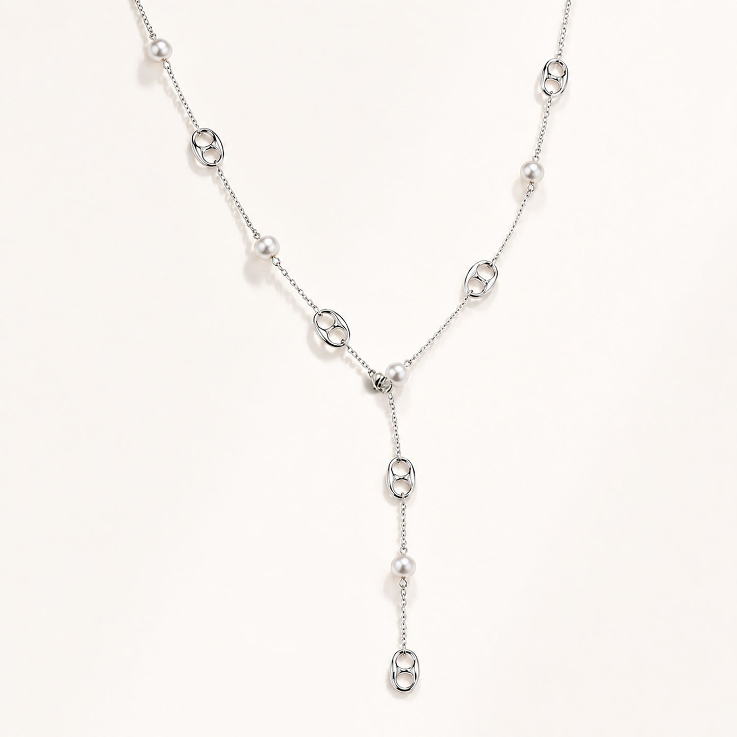 Elegant silver-tone lariat necklace featuring mother-of-pearl and anchor links on a white background.