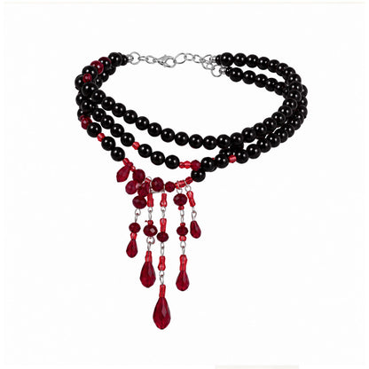 Jet black multi-strand pearl choker with cascading red crystal blood drop pendants on white background