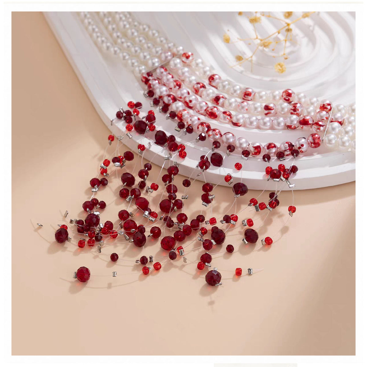 Detailed shot of bloody splattered white pearls and cascading red crystal teardrop strands