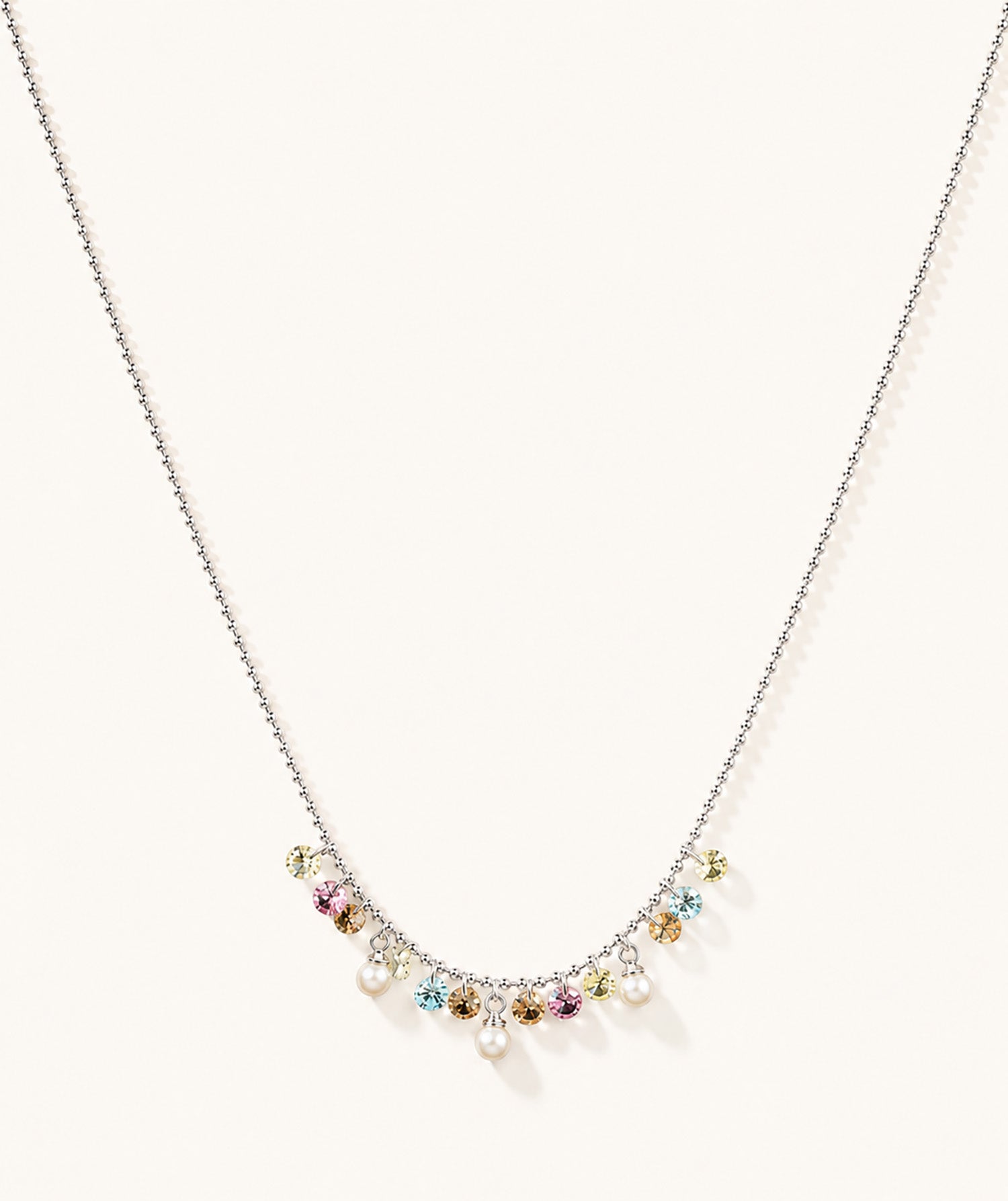 Minimalist white gold-tone necklace featuring a pastel rainbow zirconia and pearl fringe on a clean white background.