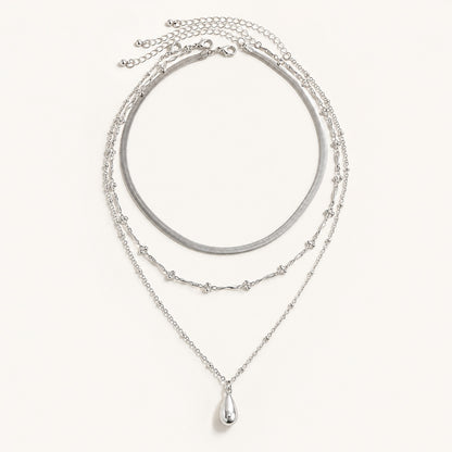 Silver 3 piece layered necklace set featuring snake chain and teardrop pendant on white background