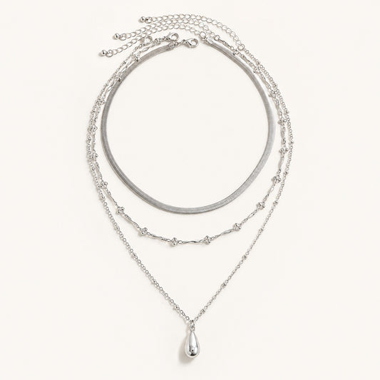 Silver 3 piece layered necklace set featuring snake chain and teardrop pendant on white background