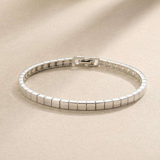 High-shine silver mirror ice cube block link bracelet with fold-over clasp on beige silk
