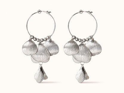 Pair of silver-plated hoop earrings featuring cascading textured leaf and shell petals on a plain background.