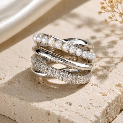 Close-up detail of a silver-tone multi-band crossover ring with lustrous crystal pearls and sparkling cubic zirconia stones.