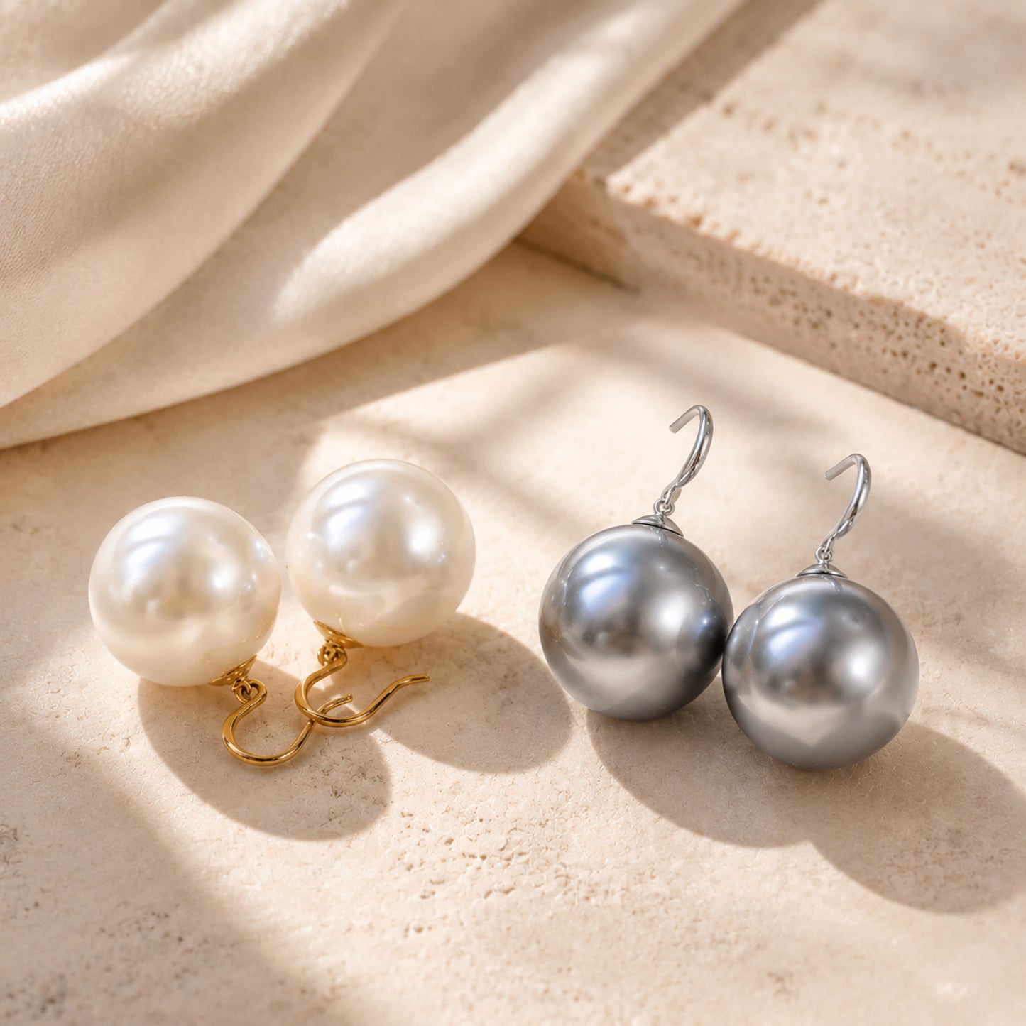 Elegant display comparing oversized pearl drop earrings in both 14K gold-tone and silver-tone finishes on a textured aesthetic stone.