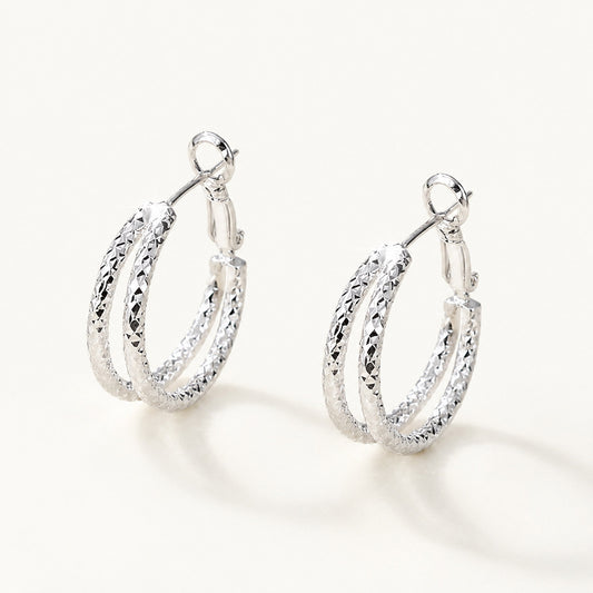 Minimalist textured double hoop earrings in a sleek white gold-tone on a white background.
