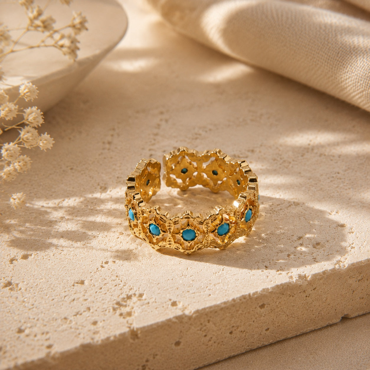 Vintage turquoise and zircon open ring resting gracefully on a textured stone surface in warm, natural sunlight.