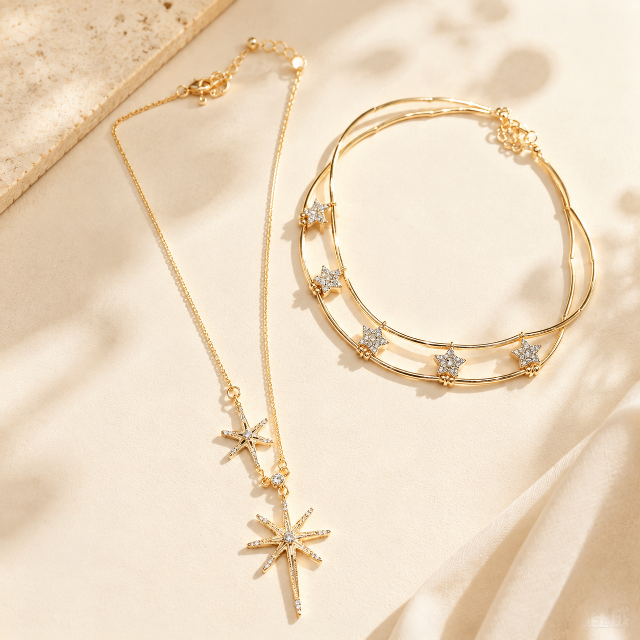 Elegant gold-tone layered necklace with cubic zirconia star and sunburst motifs displayed beautifully on an aesthetic stone and soft silk surface.