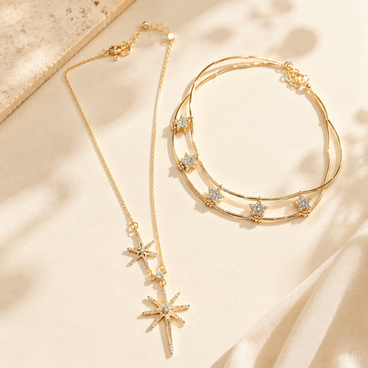 Elegant gold-tone layered necklace with cubic zirconia star and sunburst motifs displayed beautifully on an aesthetic stone and soft silk surface.