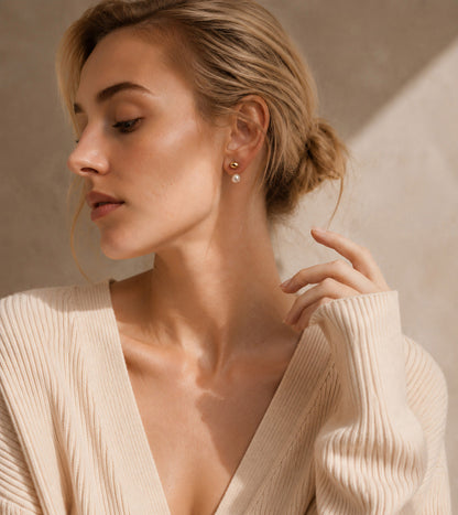 Elegant woman wearing minimalist 18K gold-plated front-back earrings with a freshwater pearl drop in warm sunlight.