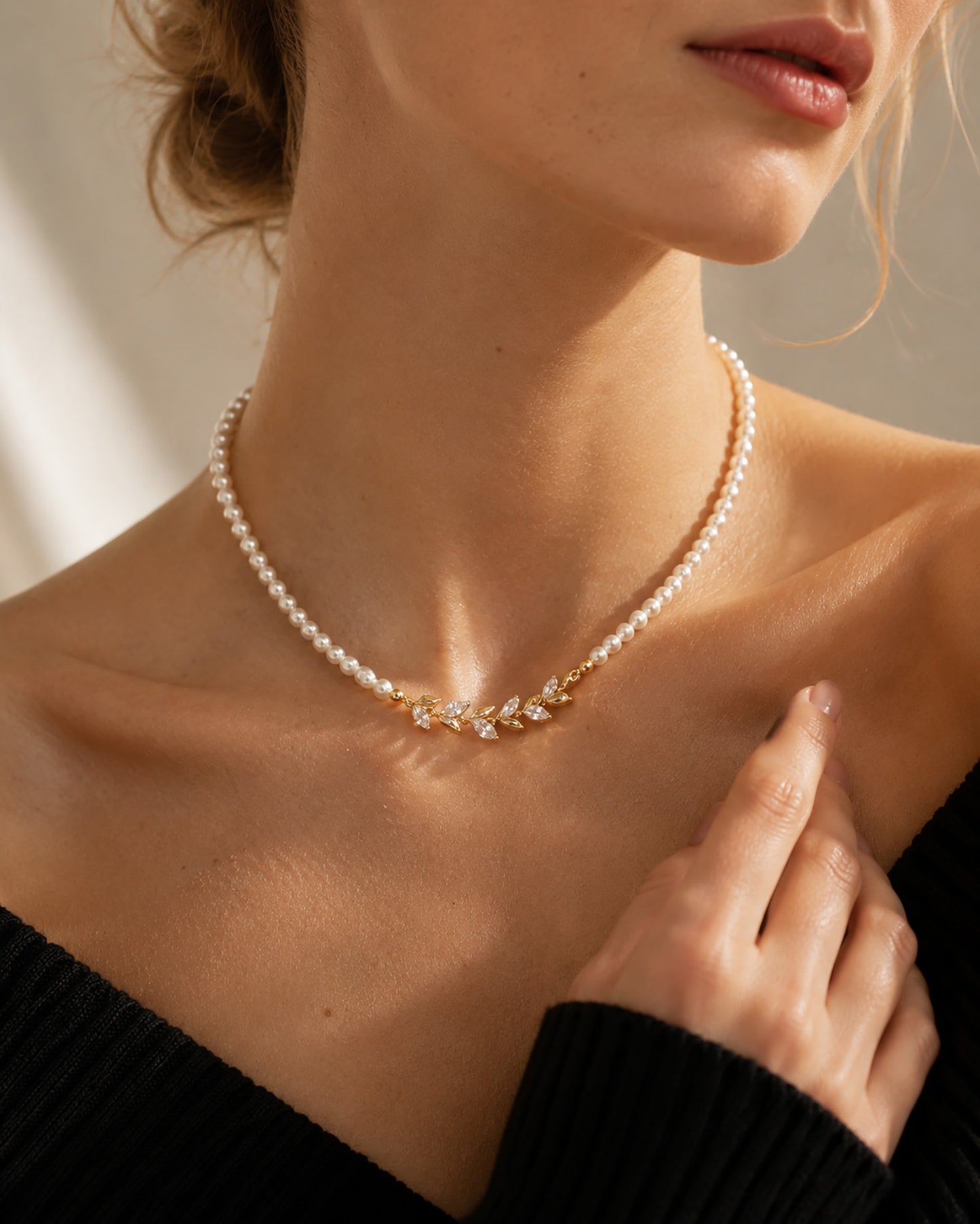 Close-up of an elegant woman wearing a vintage-inspired simulated pearl choker with a sparkling gold-tone zircon leaf centerpiece.